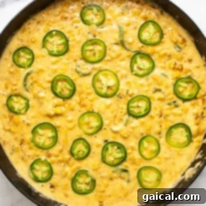 A skillet filled with corn and jalapenos.