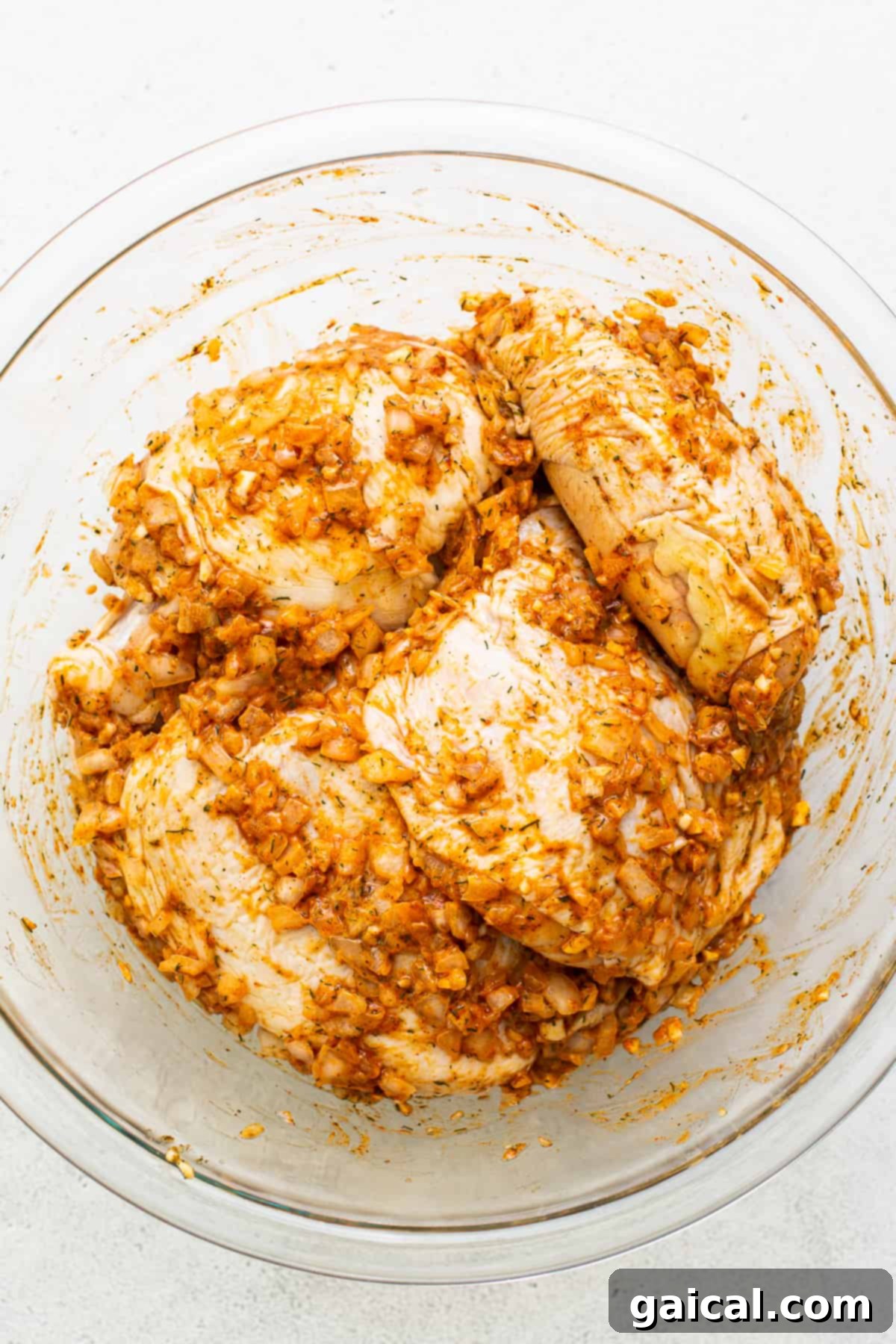 Marinating Chicken Thighs Chicken thighs marinating in a flavorful lemon and herb sauce in a bowl.