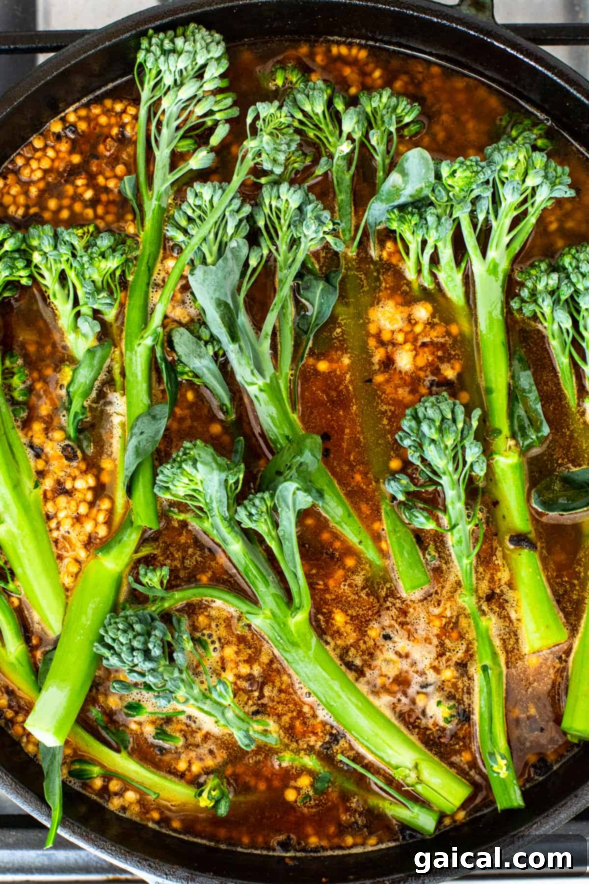 Simmering Broccolini and Couscous Broccolini and couscous simmering in a skillet on the stovetop.