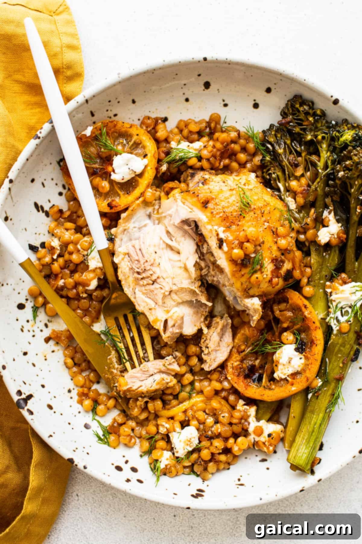 Lemon Chicken Skillet Plated A beautifully plated Lemon Chicken Skillet with couscous and broccolini, garnished with fresh dill.