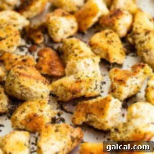 Freshly pan-fried homemade croutons spread on a baking sheet to cool.