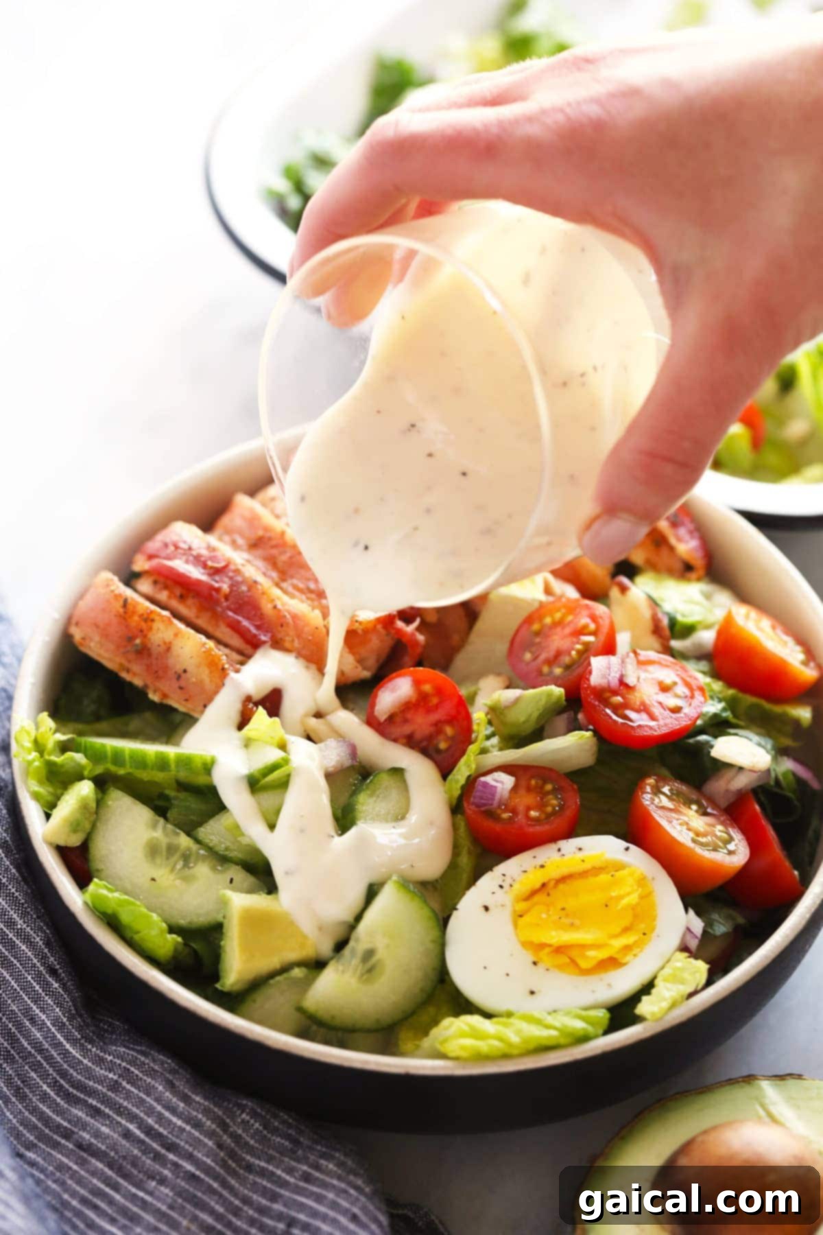 pouring dressing over a fresh salad