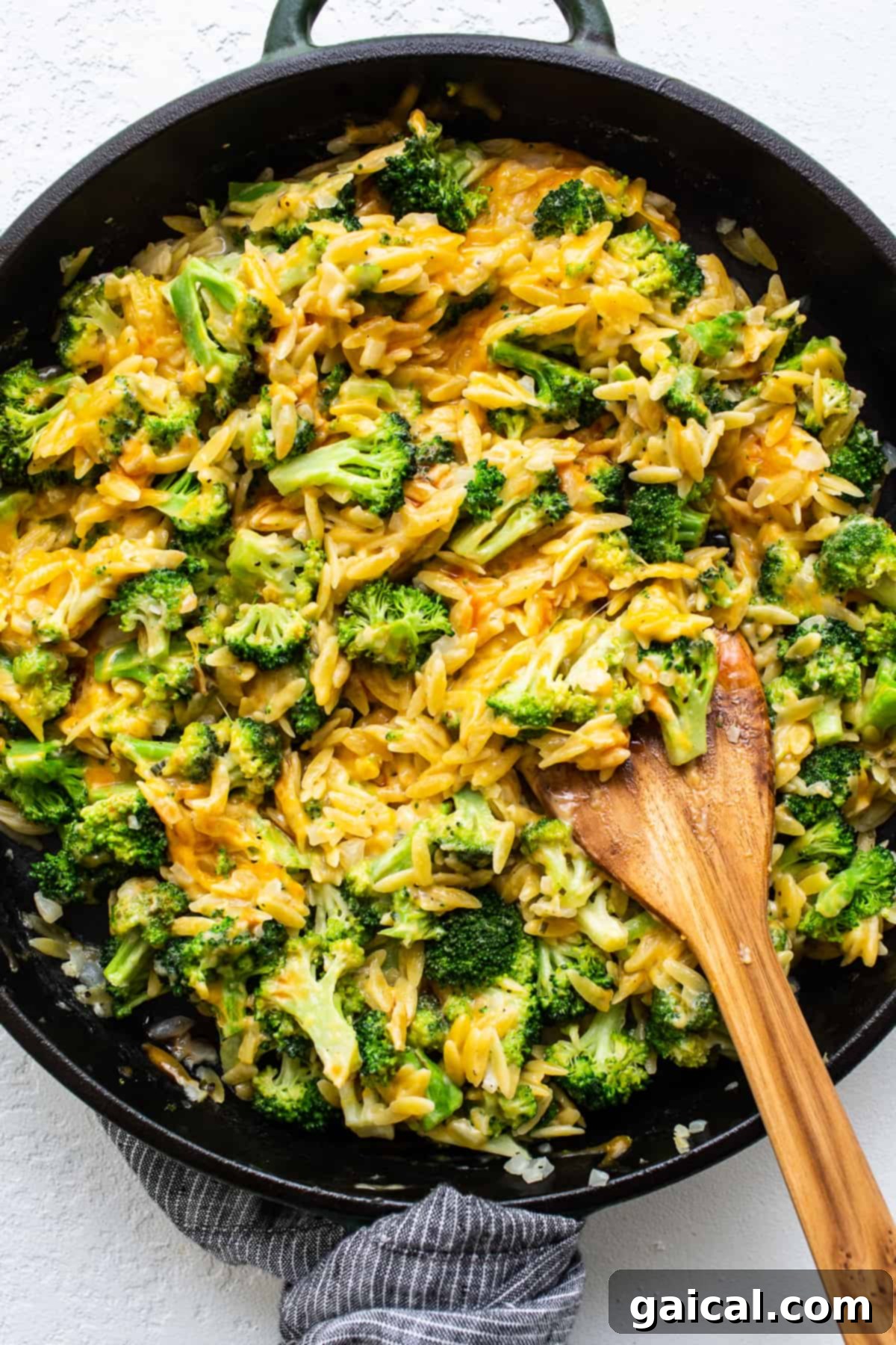 Delicious Skillet Broccoli Cheese Casserole with Orzo A bubbling, cheesy broccoli casserole with golden orzo, fresh green broccoli florets, and melted cheddar, served in a rustic cast iron skillet.