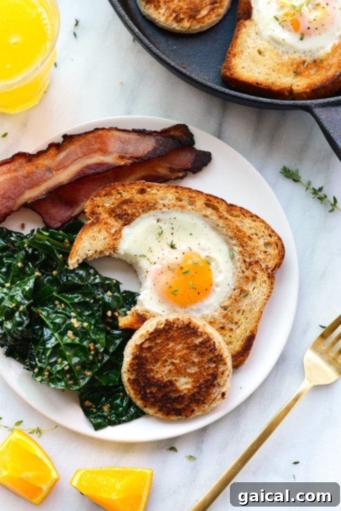 Eggs in a Basket (AKA Egg in a Hole) is such a fun twist on breakfast. Crack your egg right into a piece of toast for an open-face breakfast sandwich! Eggs in a basket with a bite taken out, resting on a plate with a side of toasted bread center