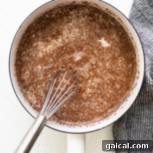 A frying pan with a whisk in it, combining the oatmeal ingredients.