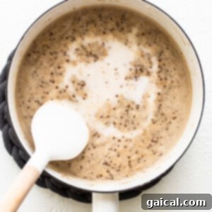 A pot of coffee with a spoon in it, illustrating the simmering process of the oatmeal.