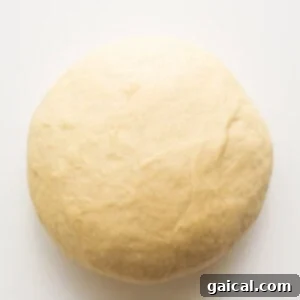 A ball of dough rising in a bowl.