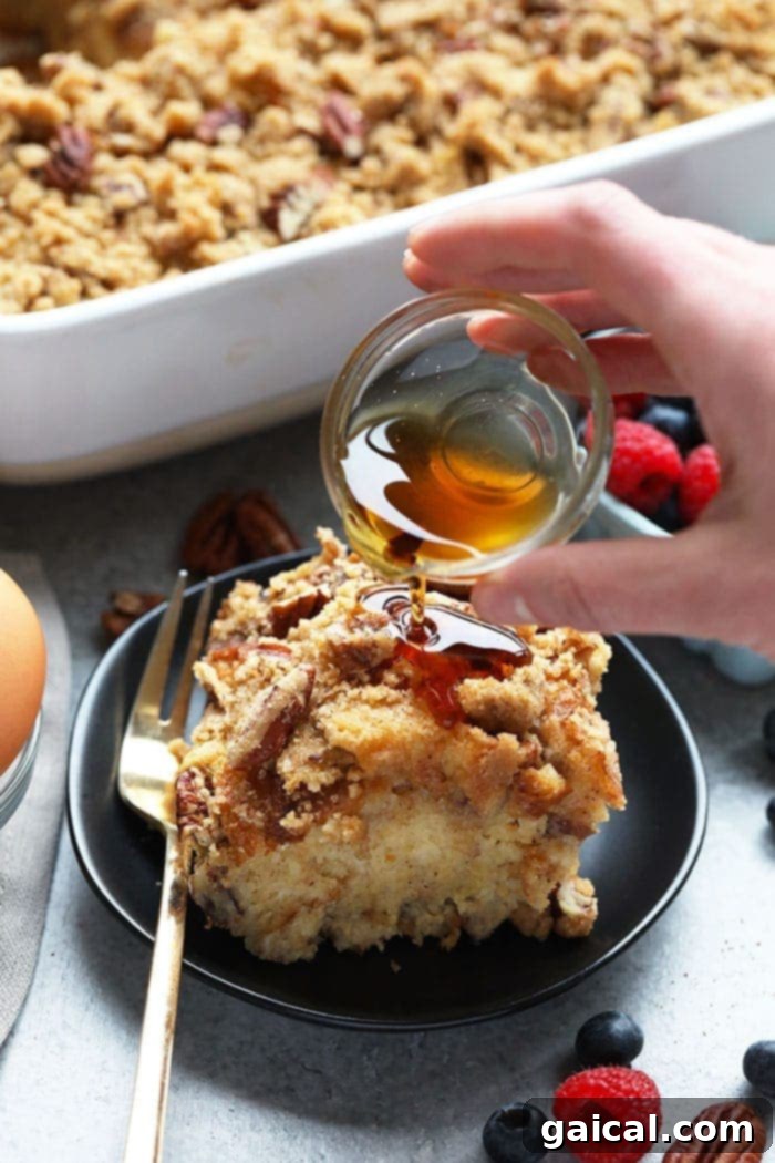 Maple Pecan Overnight French Toast Bake with Sourdough Pouring syrup on french toast bake
