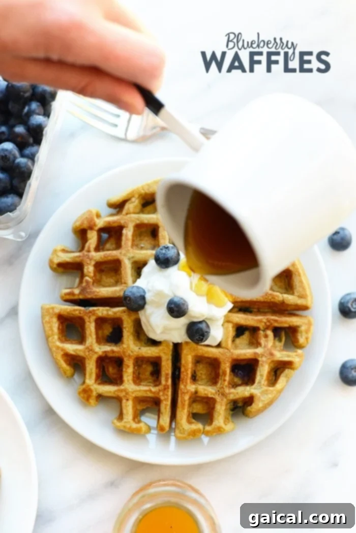 Healthy Blueberry Waffles: Whole Grain & Refined Sugar-Free Blueberry waffles being drizzled with syrup