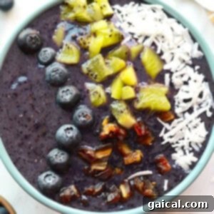 Blueberry Smoothie Bowl filled with blueberry, coconut, and kiwi smoothie.