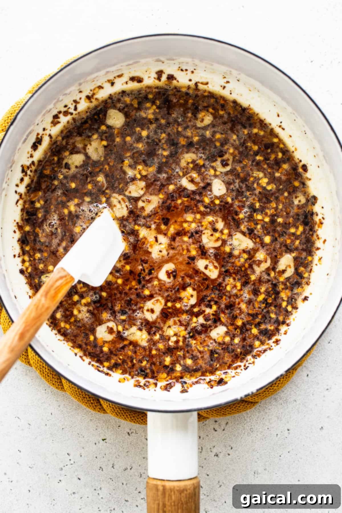 Our 4-ingredient hot honey sauce is hot, sticky and a little sweet. It's the perfect sauce to drizzle over chicken, seafood, pizza, roasted veggies and more! Hot honey ingredients gently simmering in a saucepan.