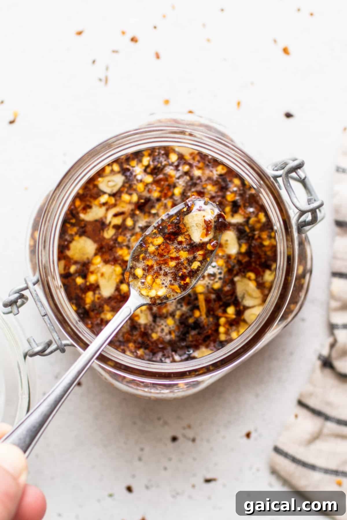 Our 4-ingredient hot honey sauce is hot, sticky and a little sweet. It's the perfect sauce to drizzle over chicken, seafood, pizza, roasted veggies and more! A mason jar filled with freshly made hot honey sauce.