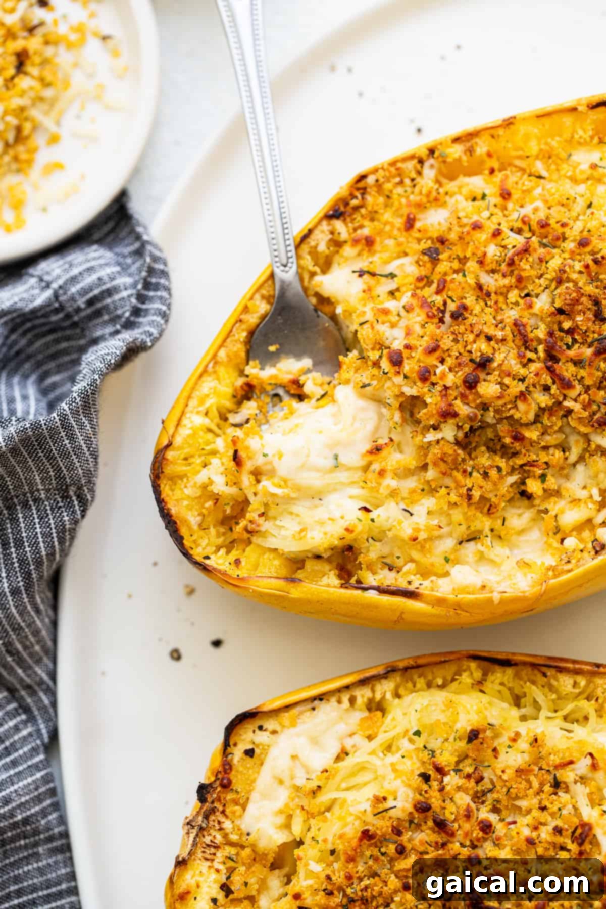 Delicious Spaghetti Squash Mac and Cheese with a fork, showing creamy squash strands and a golden topping.