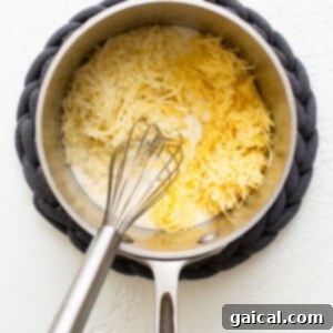 A pan with butter and pepper, with flour added to form a roux, being whisked.