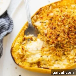 A yellow squash casserole with a spoon on a plate, featuring a perfectly browned and crispy topping.