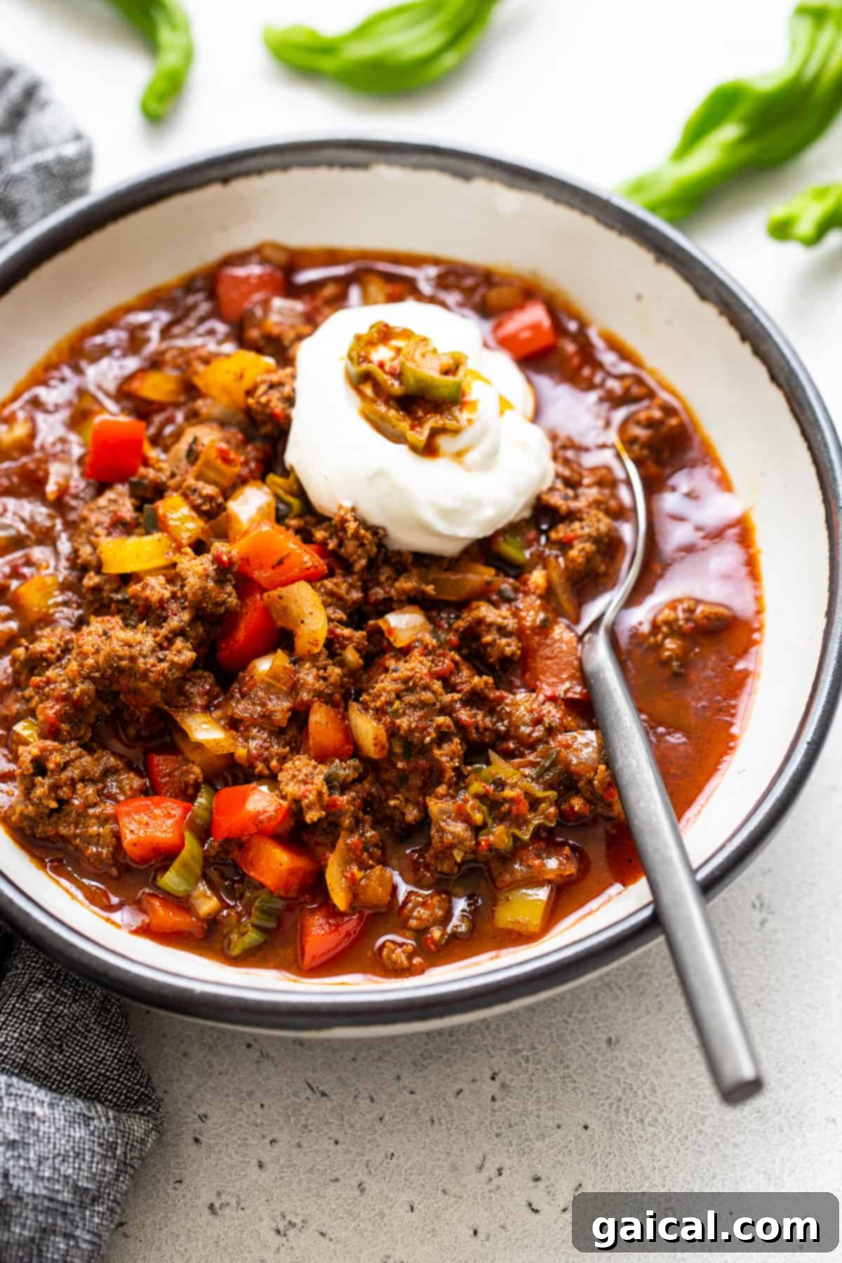 Hearty Texas Red 2 A steaming bowl of hearty Texas chili, generously topped with a dollop of cool sour cream, ready to be enjoyed.