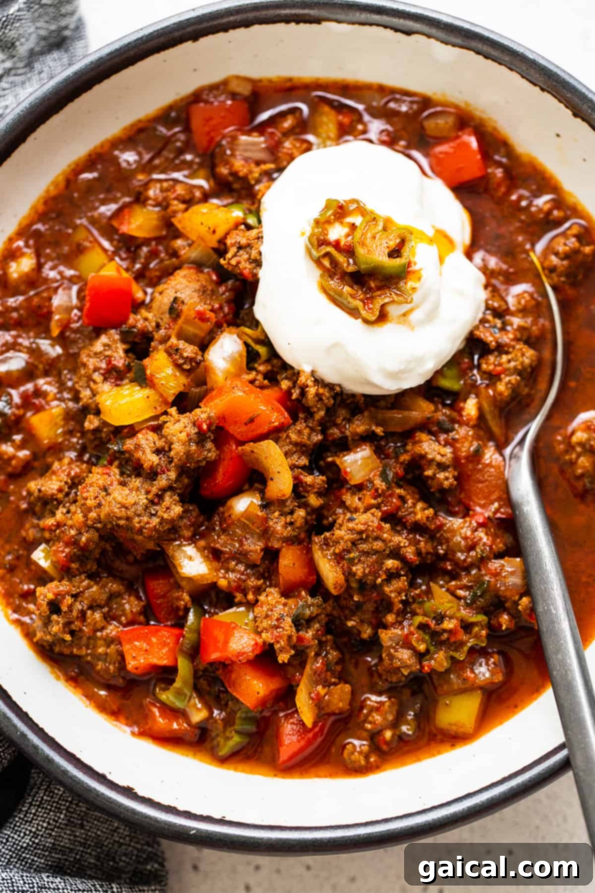 Hearty Texas Red 8 A bowl of rich Texas chili, beautifully topped with a generous dollop of sour cream, promising a comforting and flavorful meal.