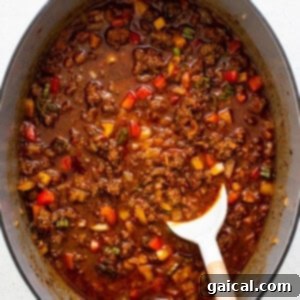 Texas chili gently simmering in a pot, releasing its rich aromas.