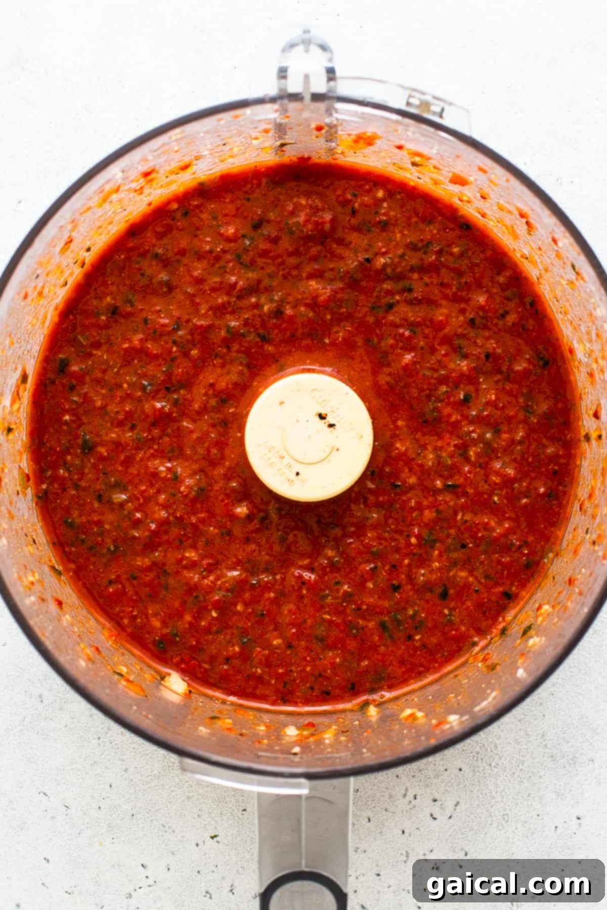 Hearty Texas Red 3 Vibrant roasted red pepper sauce being blended smooth in a food processor, forming the rich base for the Texas chili.