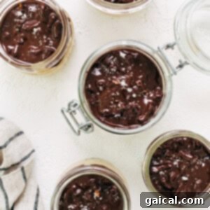 Whipped Pumpkin Spice Dream 7 Chocolate pudding in jars on a white table.
