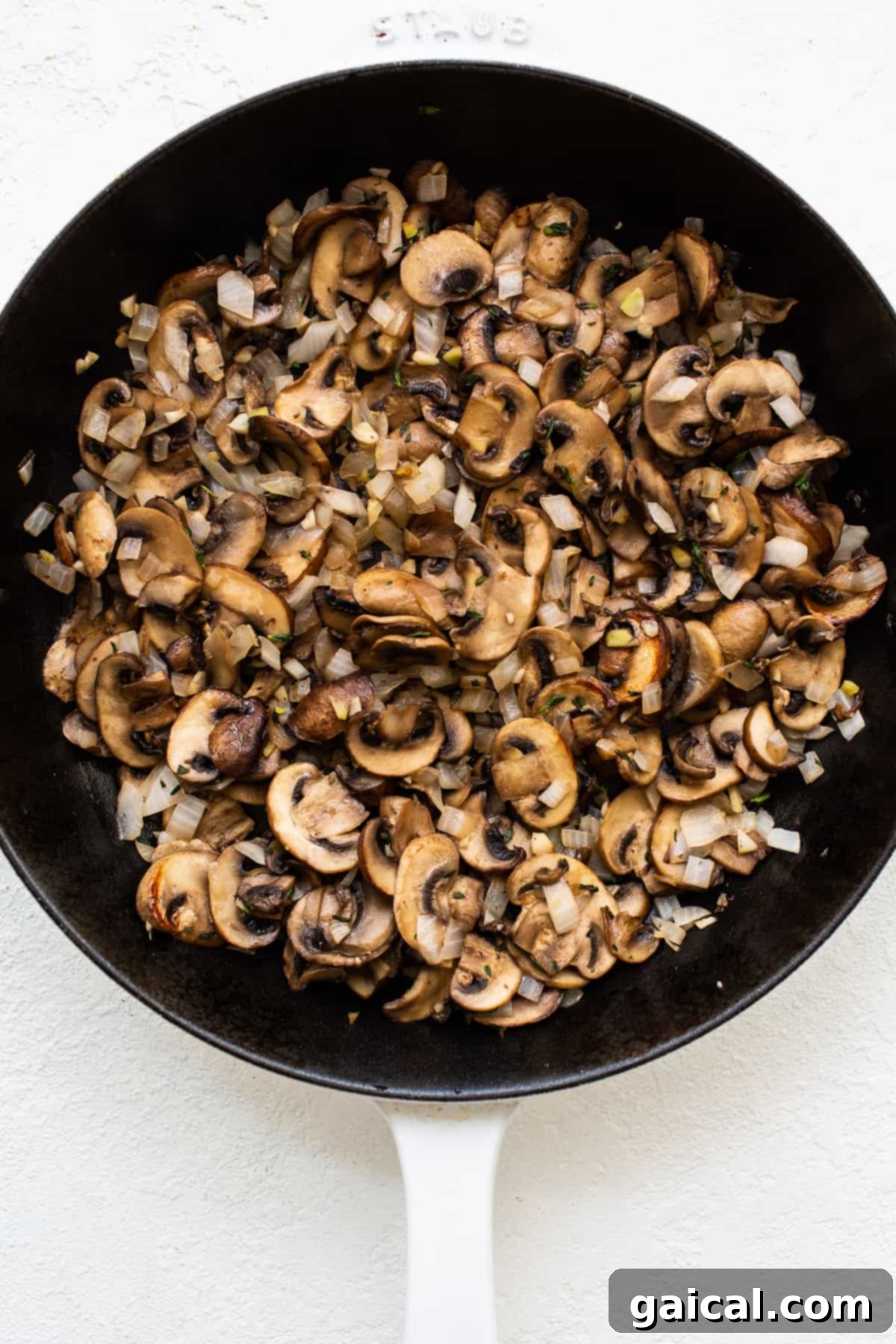 Flavorful Mushroom Filling Preparation for Stuffed Pork Chops Caramelized brown mushrooms sizzling in a hot skillet, ready for the cheesy filling.