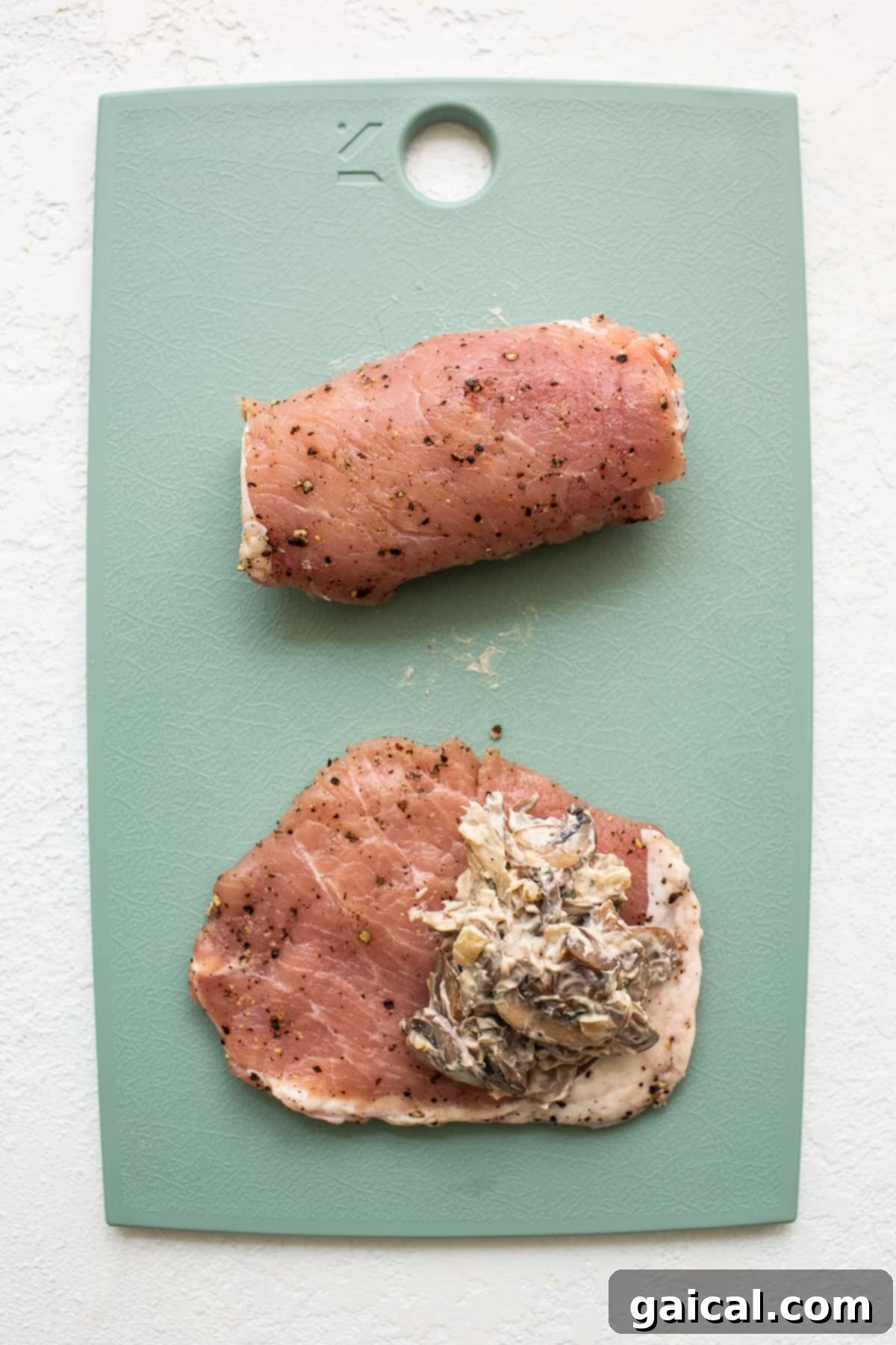 The Art of Stuffing Pork Chops with Flavorful Filling Expertly stuffing pork chops with creamy mushroom mixture on a clean cutting board.