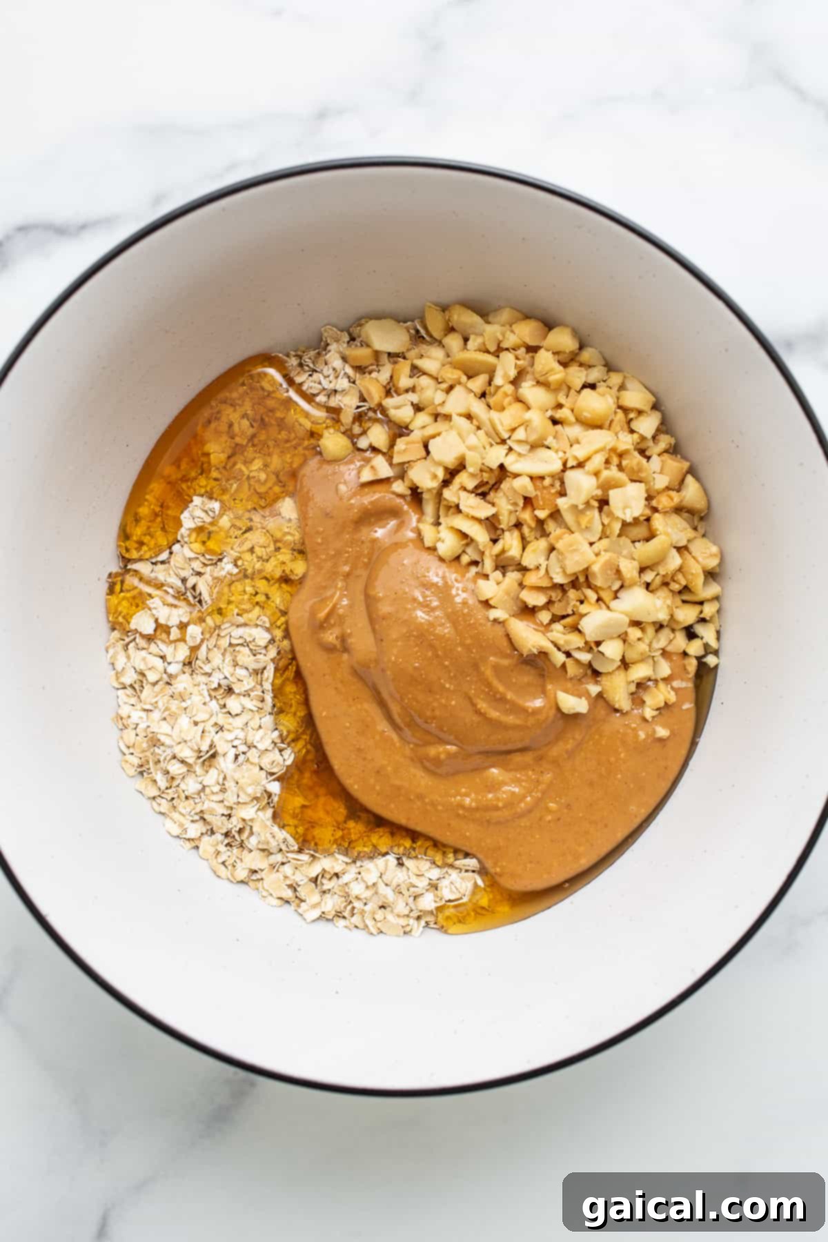 Ingredients for No-Bake Peanut Butter Oat Cups Bowl filled with ingredients for oat cups, featuring oats, honey, and peanut butter.