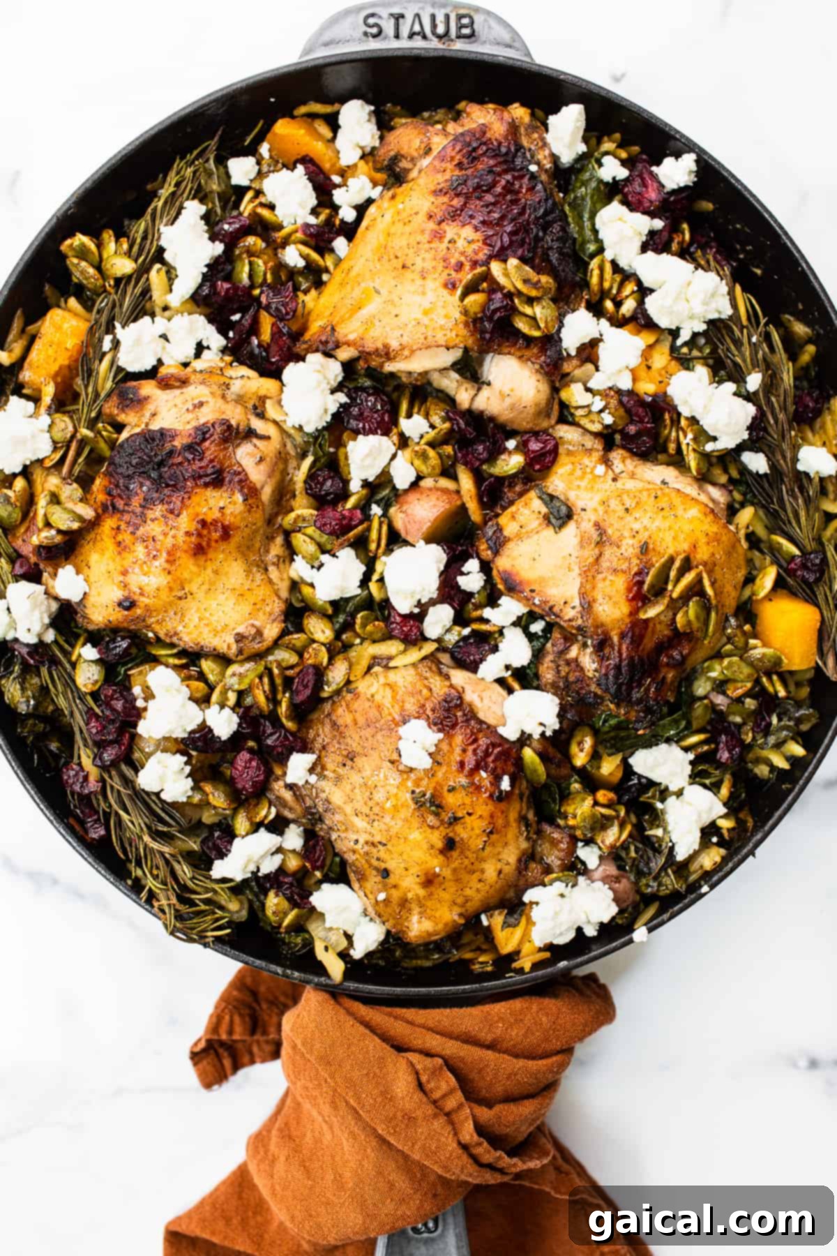 Golden Autumn Skillet Orzo 2 A vibrant Harvest Orzo Skillet, generously topped with crumbled goat cheese, ready to be served. The dish features golden-brown chicken thighs, tender orzo, and colorful fall vegetables.