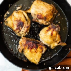 Browning chicken in a skillet, creating a delicious crispy skin.