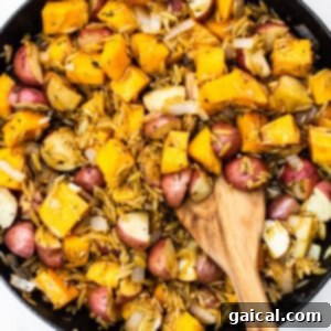 Butternut squash, red potatoes, and orzo mingled in a cast iron skillet, ready for broth.