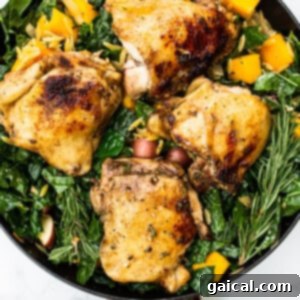 Chicken thighs and mixed vegetables assembled in a skillet, ready to be covered and baked.