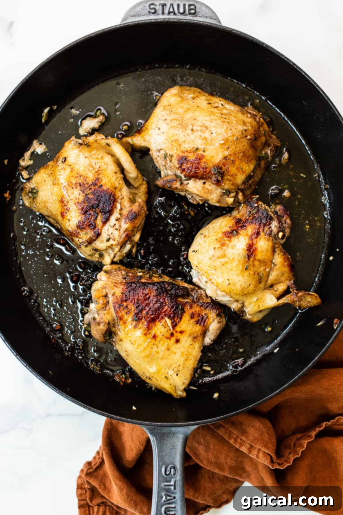Golden Autumn Skillet Orzo 3 Close-up of golden-brown chicken thighs searing in a preheated cast iron skillet, showcasing the crisp skin.