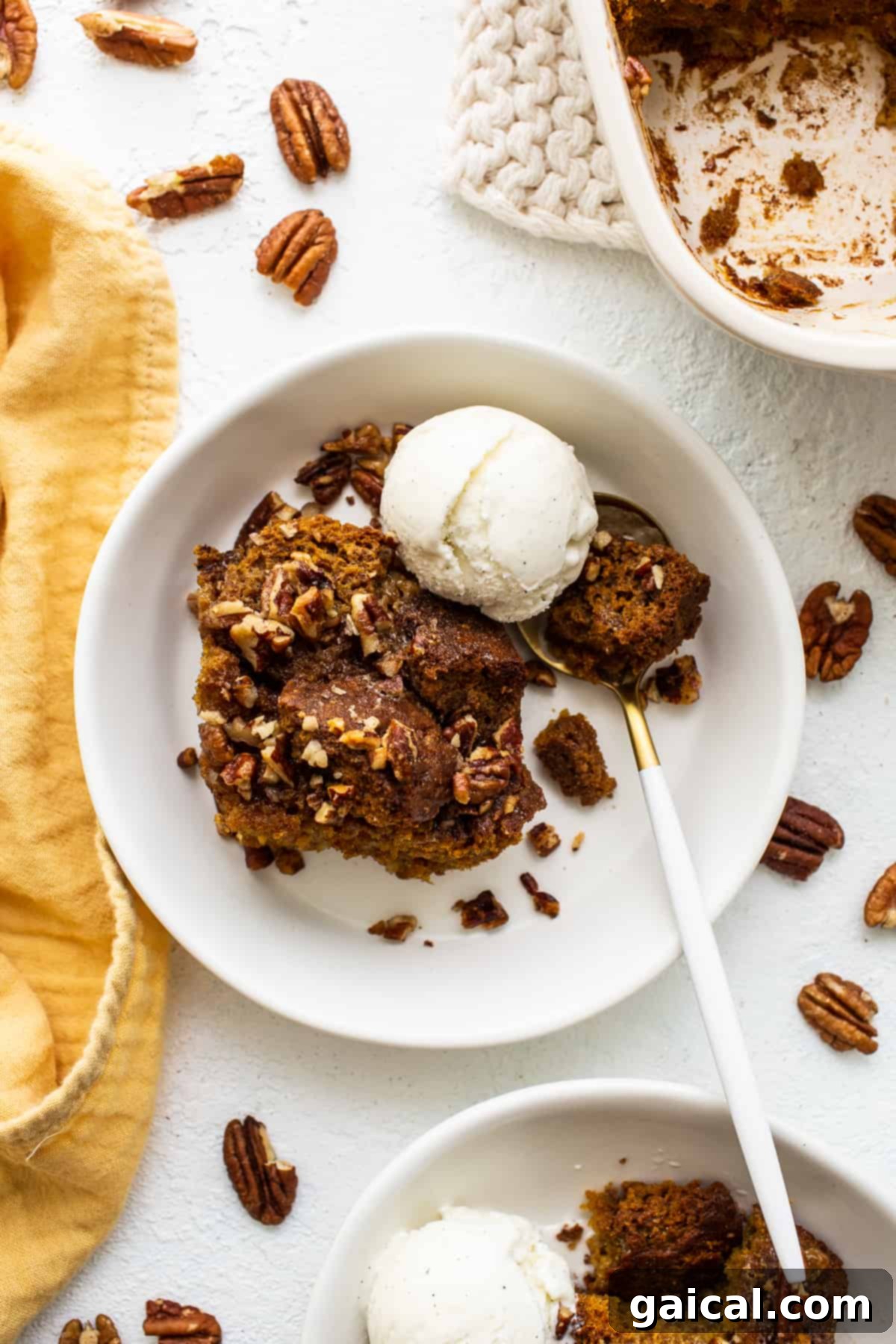 Pumpkin Bread Pudding À La Mode A beautiful serving of warm pumpkin bread pudding à la mode, perfectly topped with a melting scoop of vanilla ice cream, ready to be enjoyed.