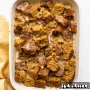 Decadent Pumpkin Bread Pudding 6 submerging pumpkin bread in baking dish.