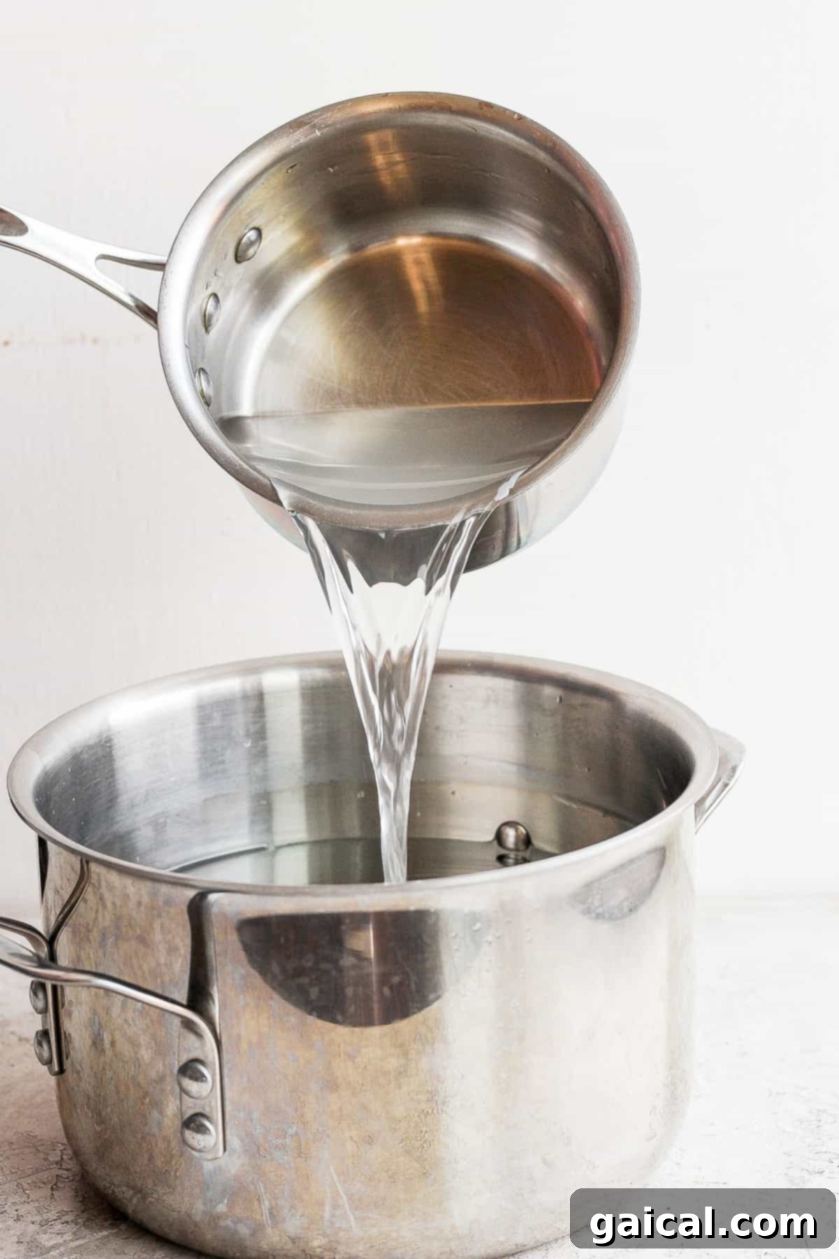 Pouring the prepared brine solution over a whole turkey in a large brining pot, ensuring full submersion.