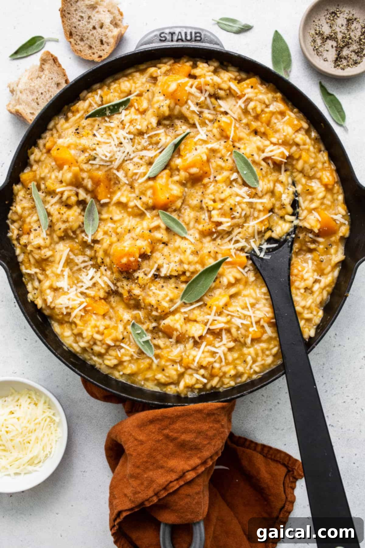 Fit Foodie Kitchen November 2022 6 A chef's hand stirring butternut squash risotto in a pan.