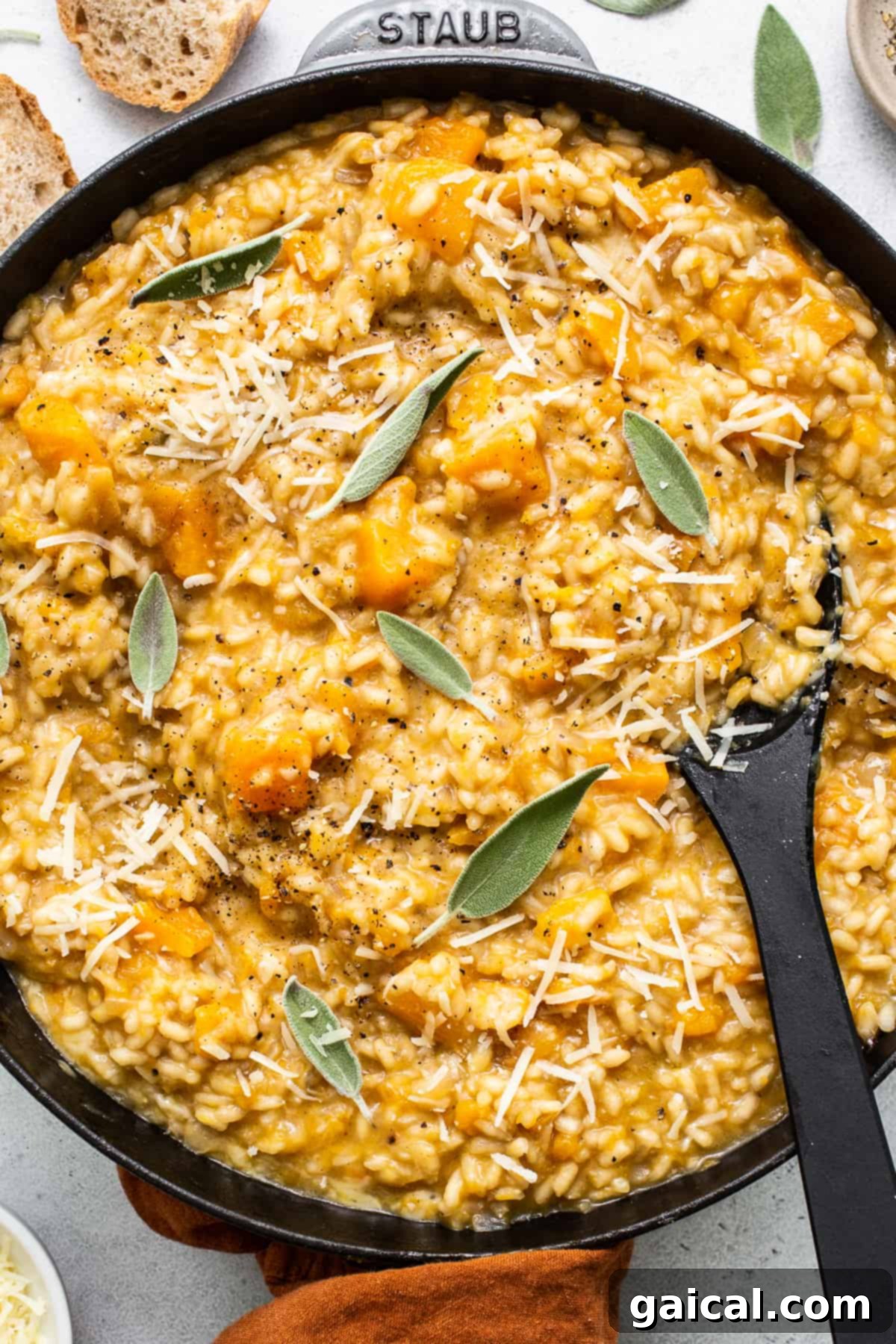 Velvety Butternut Squash Risotto 8 A glorious serving of creamy butternut squash risotto generously topped with freshly grated parmesan cheese, fragrant fresh sage leaves, and a sprinkle of cracked black pepper, ready to be enjoyed.