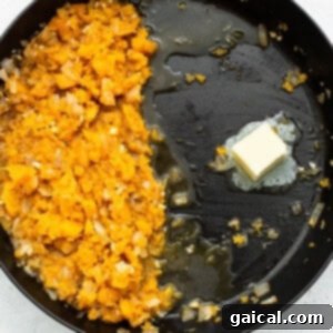 A frying pan with mashed sweet potatoes and butter, ready for rice to be toasted.