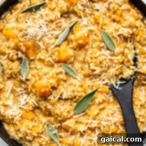 Butternut squash risotto in a skillet, beautifully garnished with fresh sage.