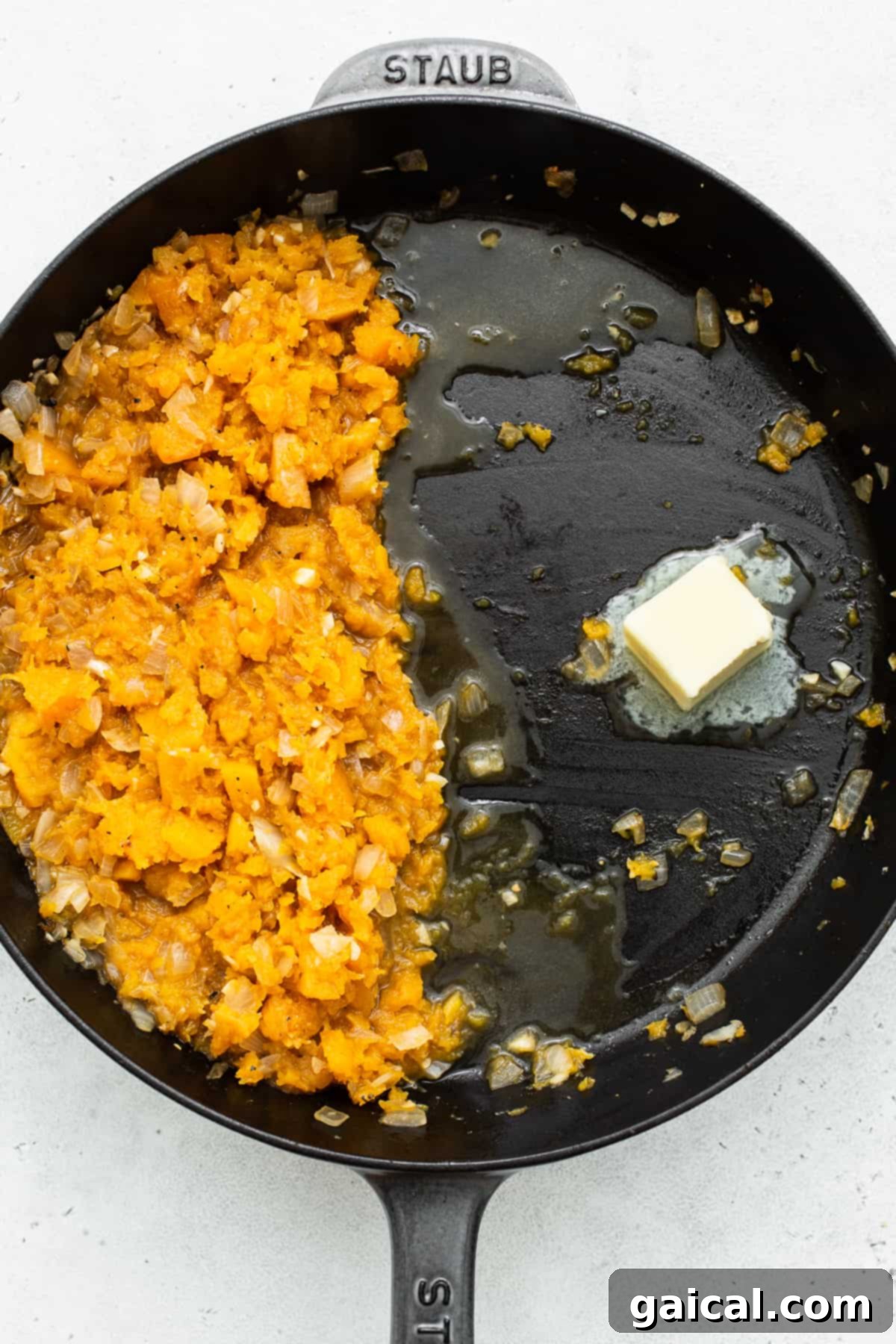 Velvety Butternut Squash Risotto 5 Rich butter melting in a skillet, preparing the pan for toasting Arborio rice, a crucial initial step in creating a perfectly textured and flavored risotto.