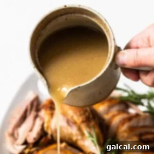 Turkey gravy in a bowl, garnished with fresh herbs, ready to be served.