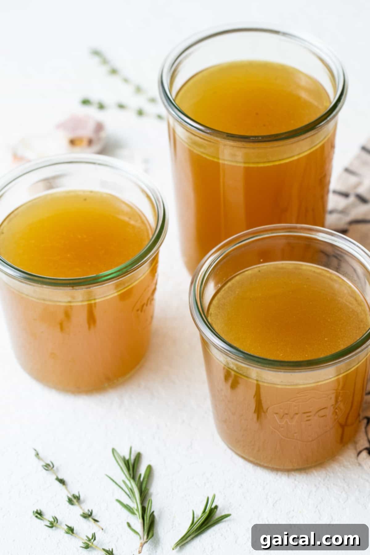 Slow Simmered Turkey Broth 2 Homemade turkey stock in clear glass jars, ready for storage or use.