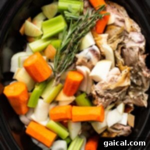 Vegetables and turkey in a slow cooker, before liquid is added.