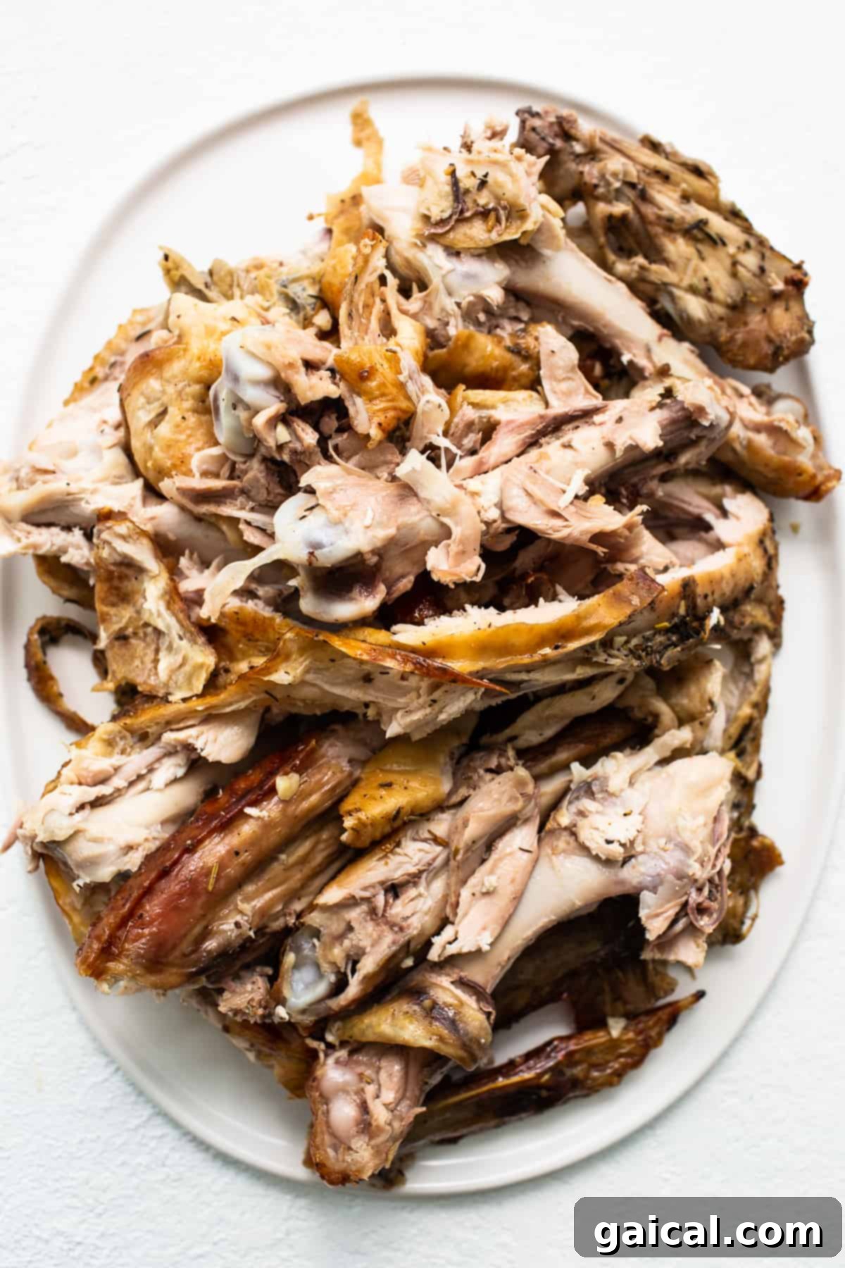 Slow Simmered Turkey Broth 3 A roasted turkey carcass with some meat remnants on a white plate, ready for stock making.