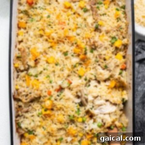 Chicken and vegetable casserole baked in a dish with a wooden spoon.
