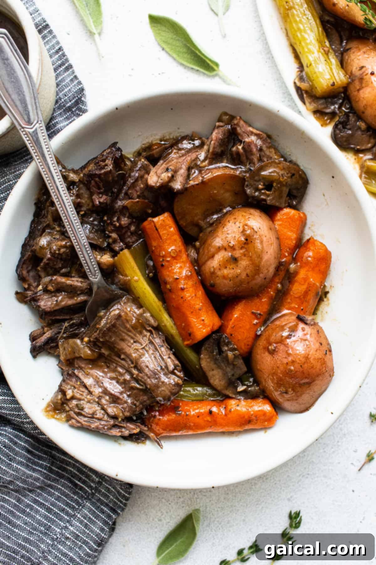Enjoying Your Tender Pot Roast A close-up of tender, shredded pot roast served in a rustic bowl with a fork, emphasizing its succulent texture and rich gravy.