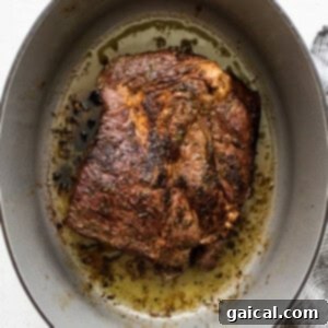 Slow-Cooked Tender Beef Roast 7 A perfectly seared piece of chuck roast with a golden-brown crust, cooking in a Dutch oven on the stovetop.