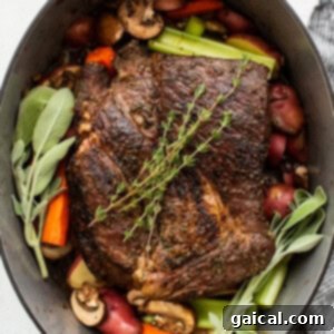 Slow-Cooked Tender Beef Roast 9 A Dutch oven filled with seared pot roast, root vegetables, and fresh herbs, ready for the braising liquid to be added.