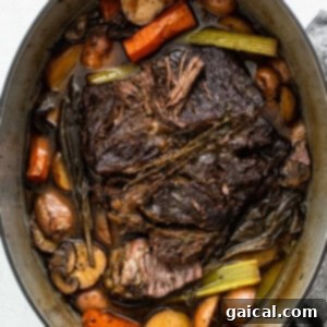 Slow-Cooked Tender Beef Roast 10 A cooked pot roast with carrots and potatoes in a Dutch oven, resting after baking.