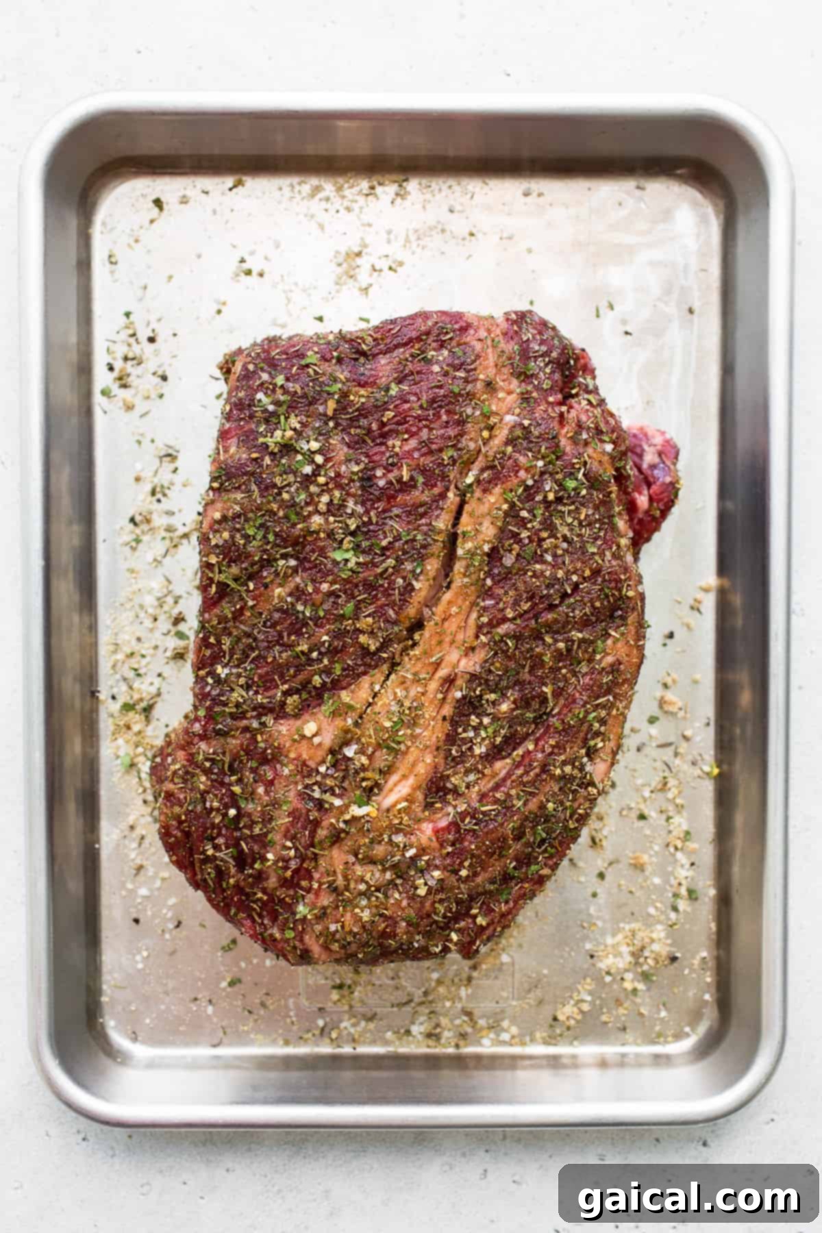 Choosing the Right Cut: Boneless Chuck Roast for Pot Roast A raw, well-marbled boneless chuck roast resting on a baking sheet, ready for seasoning. This cut is perfect for a tender pot roast.